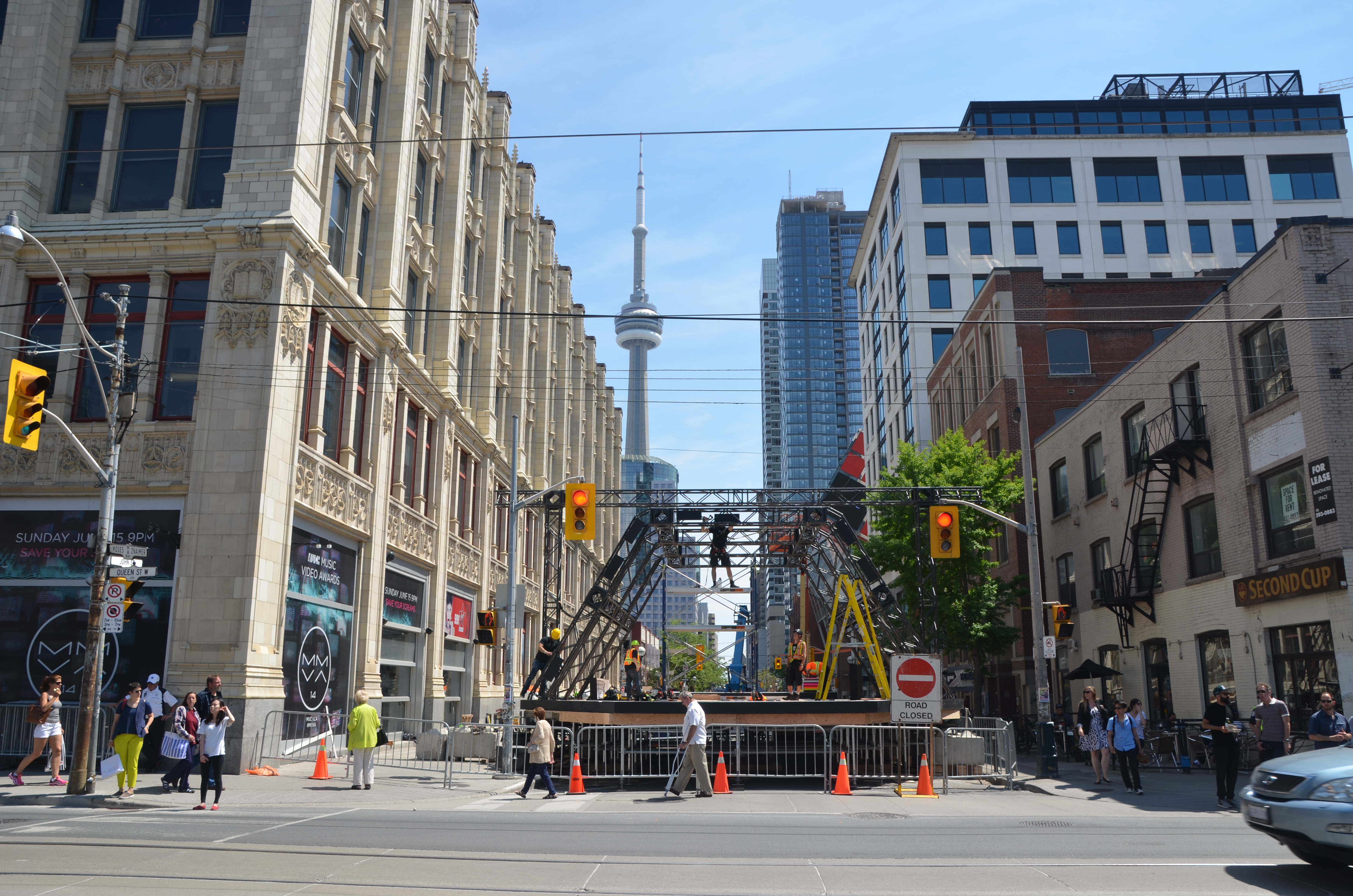 a downtown street is closed because of construction, with the CN tower in the background. 