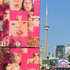 people are congregating around the base of a large water feature at the CNE, a large pink box with pictures of faces on it, the water spouts out of the mouths of the people  