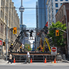 a downtown street is closed because of construction, with the CN tower in the background.  