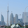 looking along a ramp of a main road, with the CN tower and the Toronto skyline in the hazy background.  