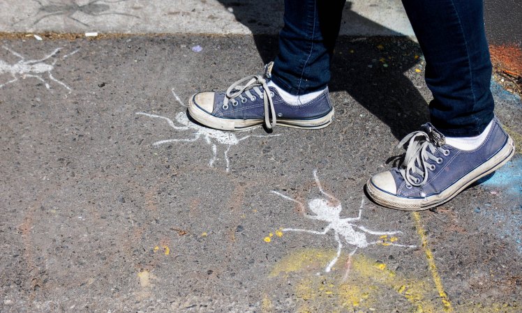stomping on painted images of ants on the sidewalk