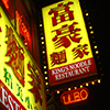brightly lit exterior sign for Kings Noodle restaurant taken at night