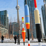 large colourful sculptures that look like buoys with downtown Toronto and the CN Tower in the background 