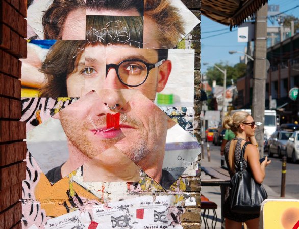 poster that is a collage of face parts on a wall in Kensington