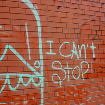 Graffiti of the words I Can't Stop written on a brick wall. 