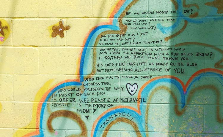 poetry written on a painted brick wall. The poem is about Monty the cat