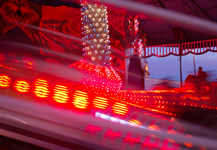 pink and purple blur lights blur together as a midway ride goes quickly around