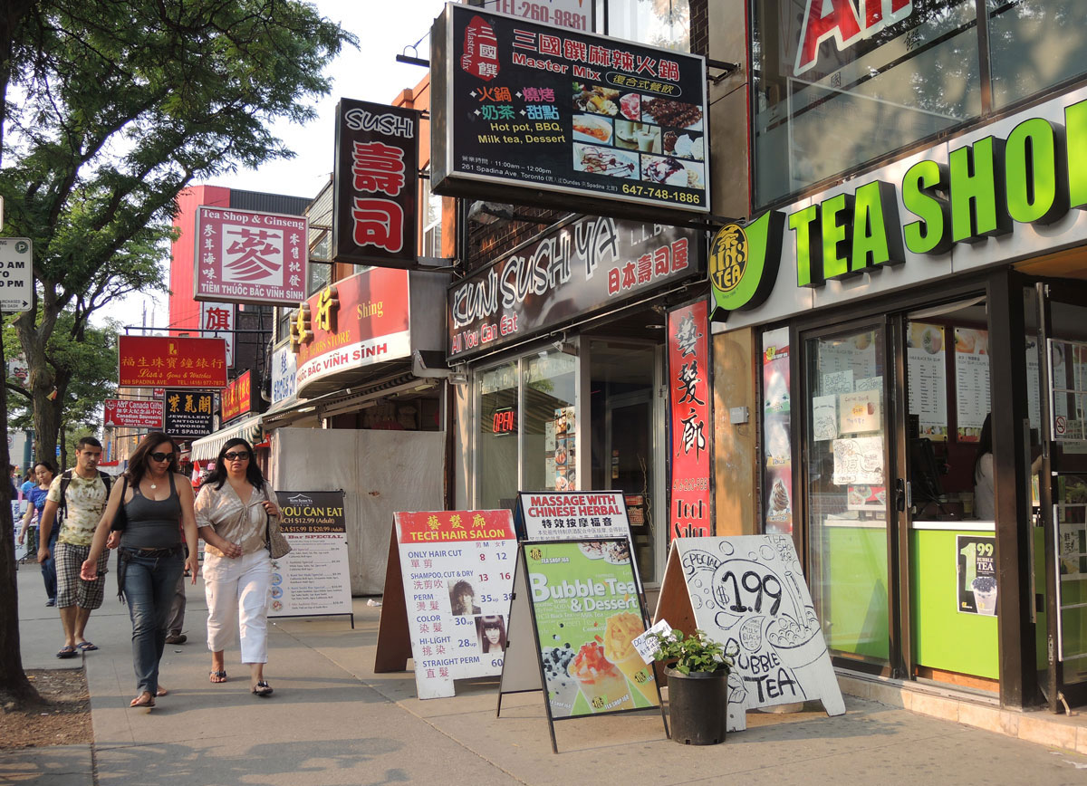 line of shops in Chinatown with boards advertising their wares outside