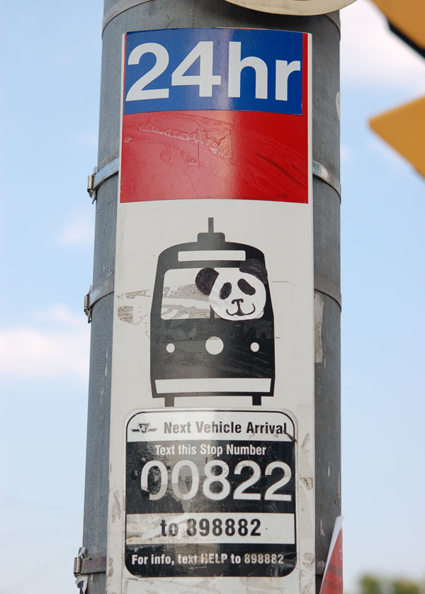 sticker of a panda bear on a TTC bus stop sign